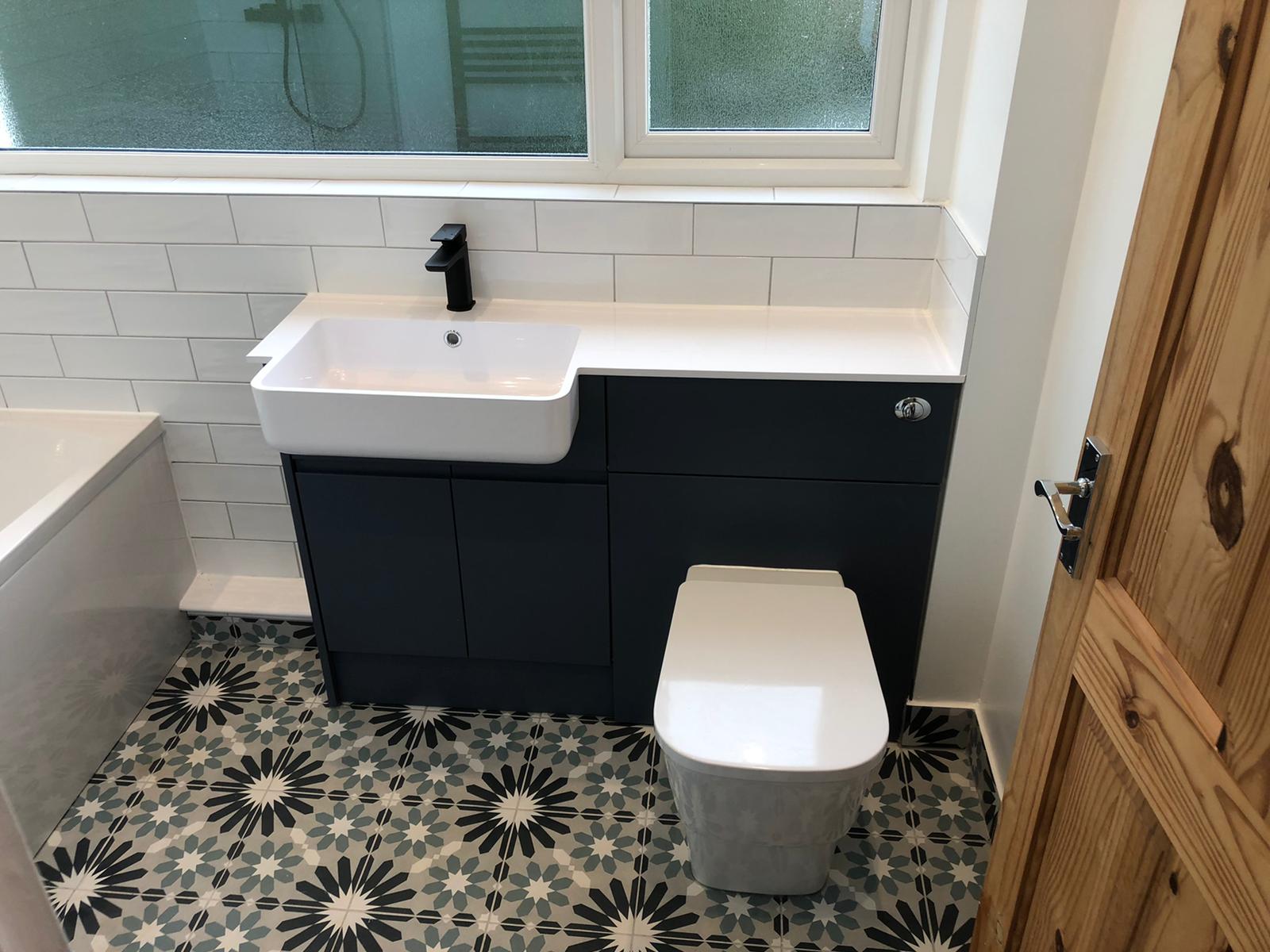 Family bathroom with navy vanity unit and patterned encaustic floor tiles