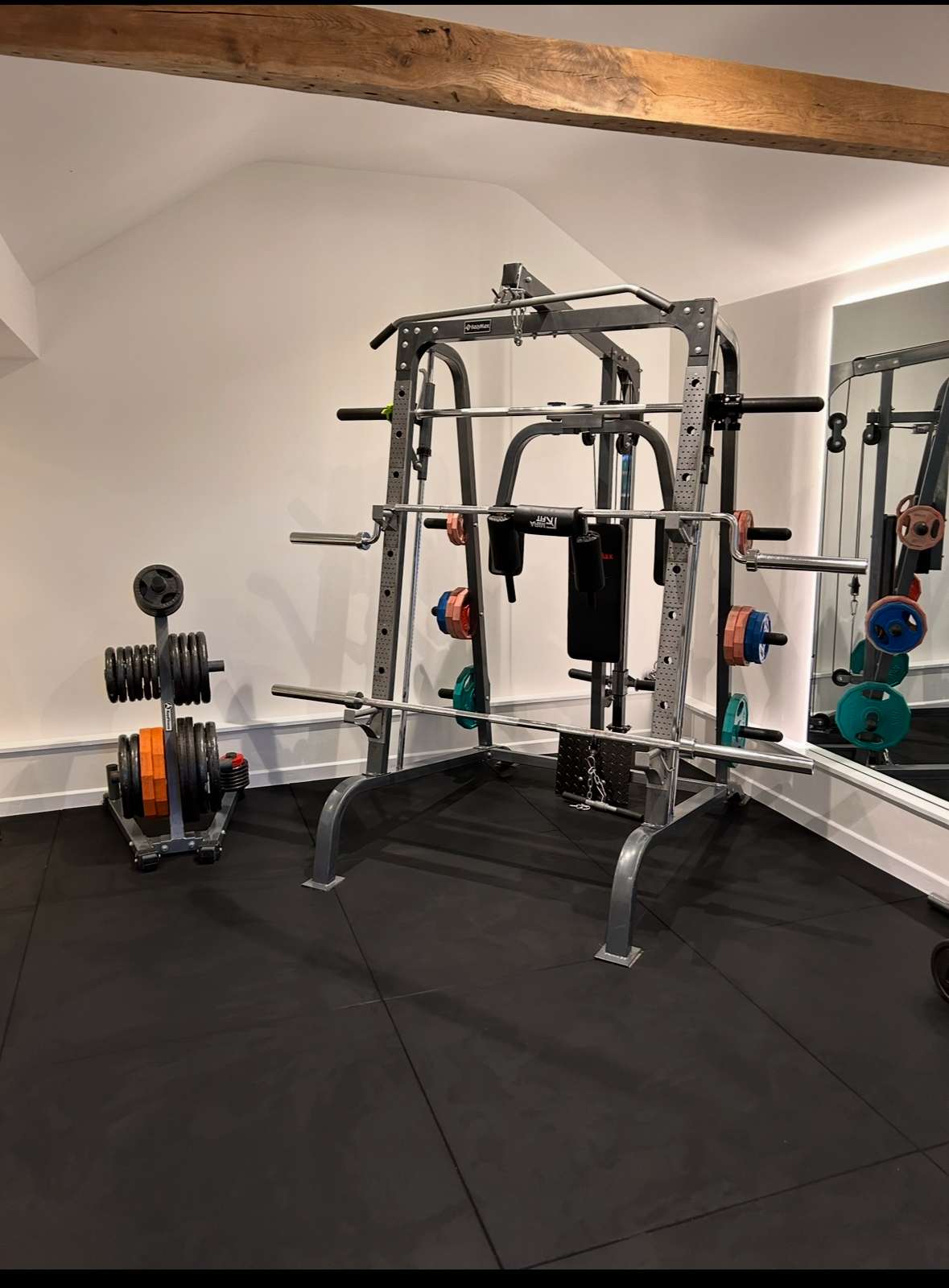 Converted home gym with exposed oak beam, squat rack and weights