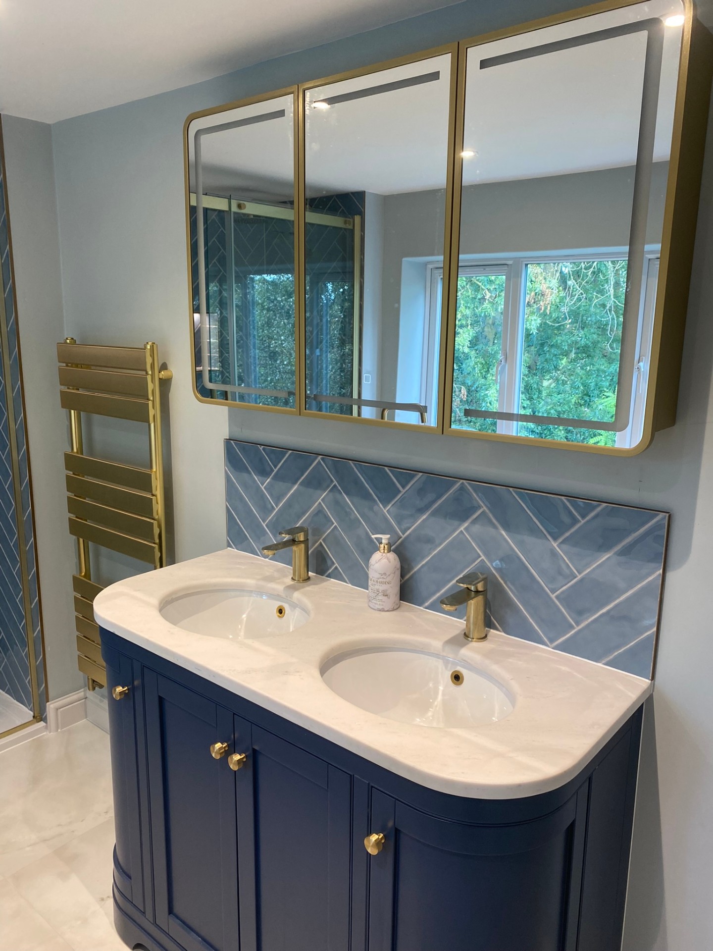 Navy vanity with double marble basins, brass taps and mirrored cabinet
