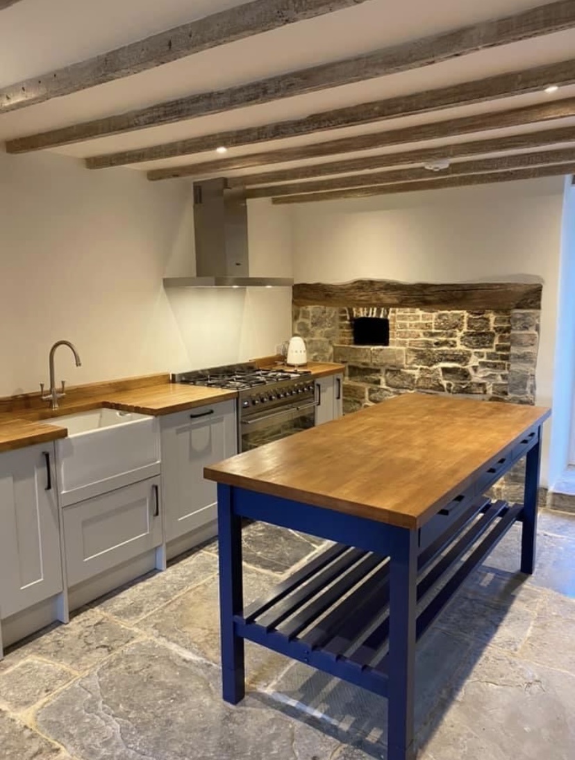 Country kitchen with exposed beams, flagstone floor and shaker units