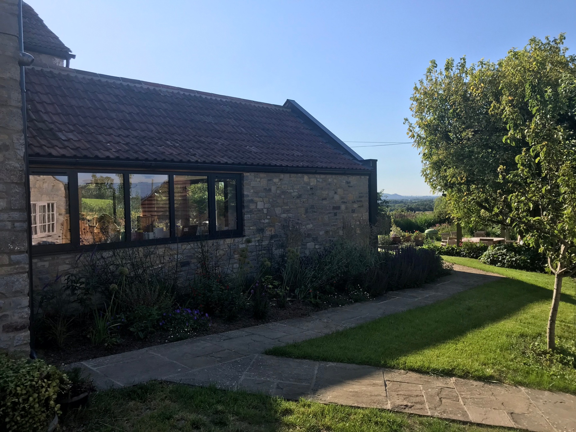 Original stone cottage in morning sunlight with views over the Somerset Levels
