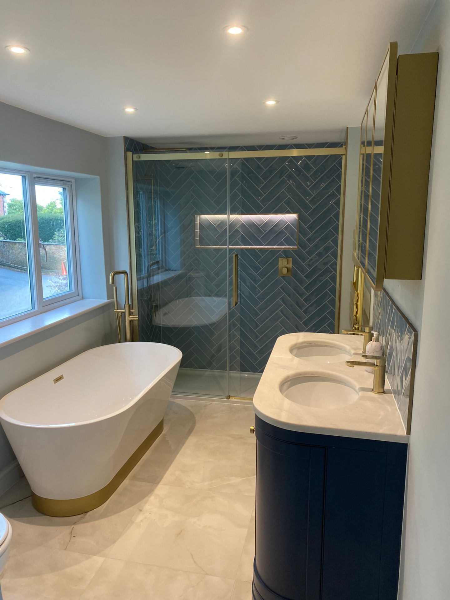 Ensuite with freestanding bath, teal herringbone shower and navy vanity