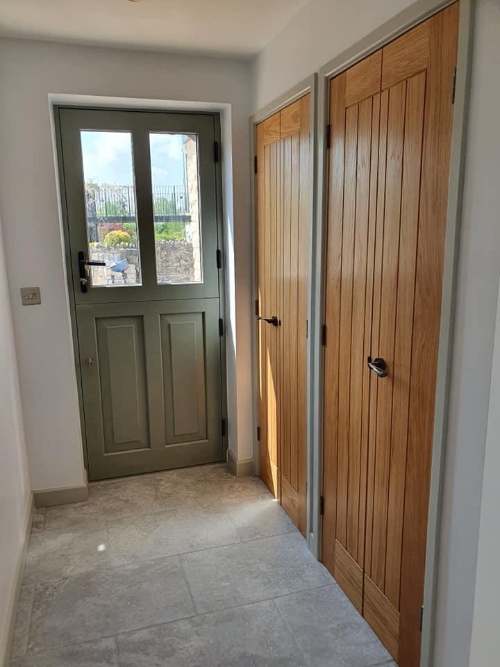 Entrance hallway with sage-green stable door and solid oak internal doors