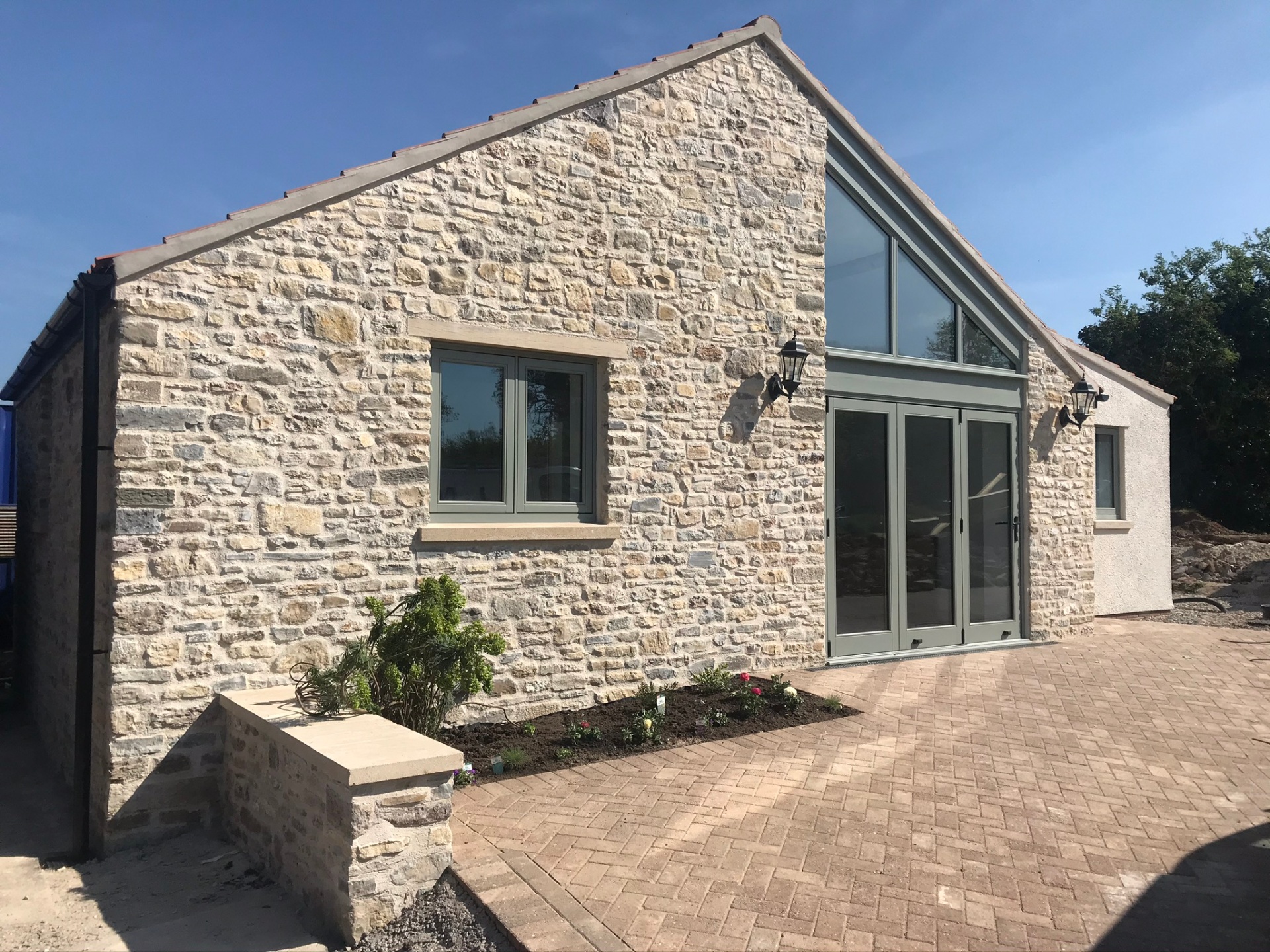 New stone-built annex with gable glazing and bi-fold doors