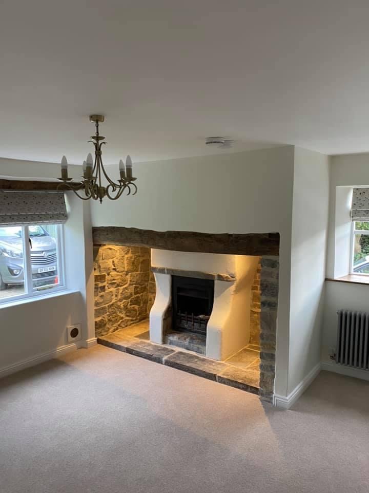 Restored inglenook fireplace with reclaimed stone and oak lintel