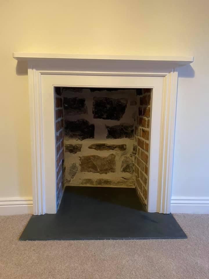 Uncovered original fireplace opening revealing stone and brickwork prior to restoration