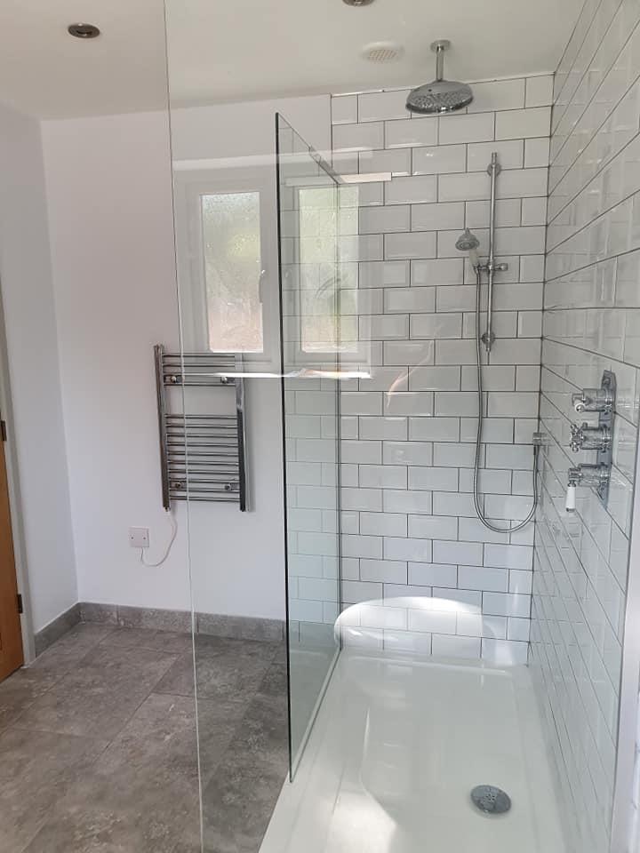 Walk-in shower enclosure with metro tiles and chrome fittings