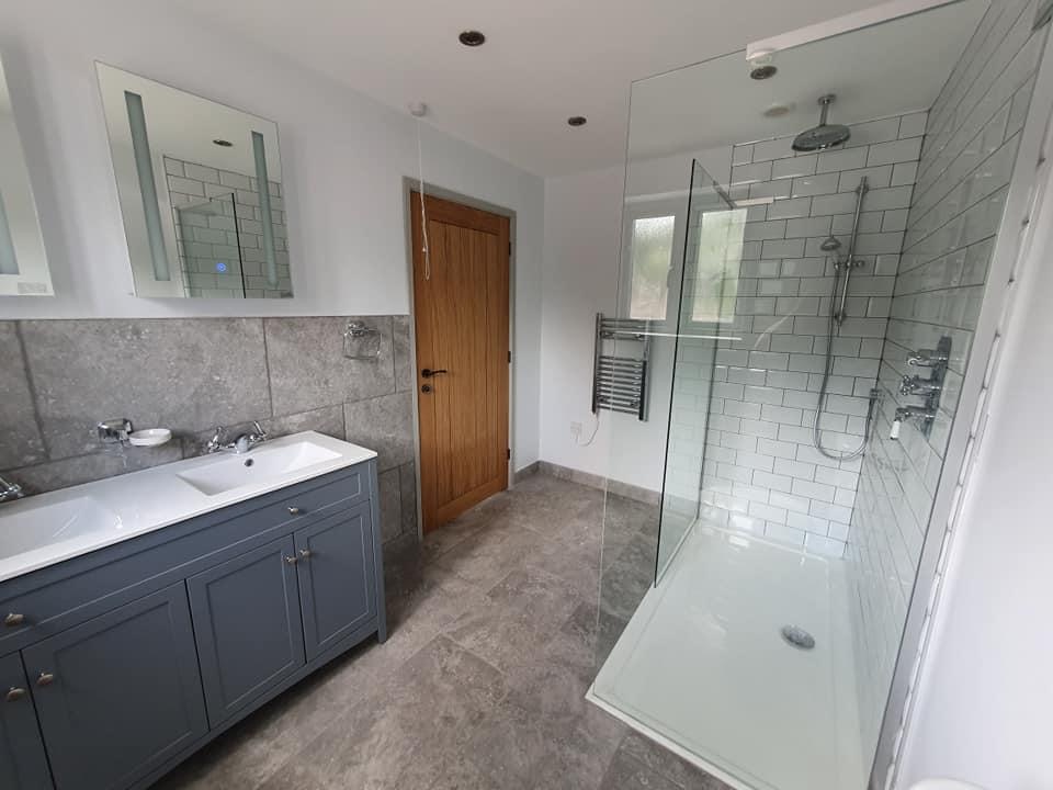 Family bathroom with double vanity, walk-in shower and metro tiling