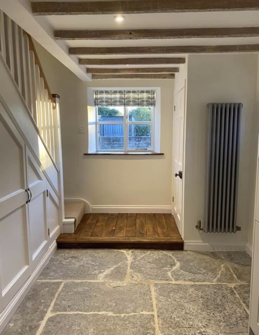 Entrance hall with exposed beams, reclaimed flagstone floor and bespoke joinery