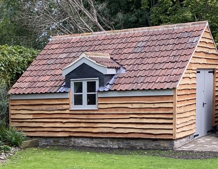 Bespoke timber-clad garden studio with clay tiled roof and dormer window