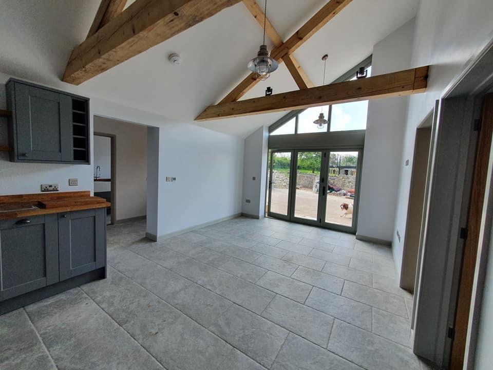 Vaulted open-plan living space with exposed Douglas fir trusses and gable-end glazing