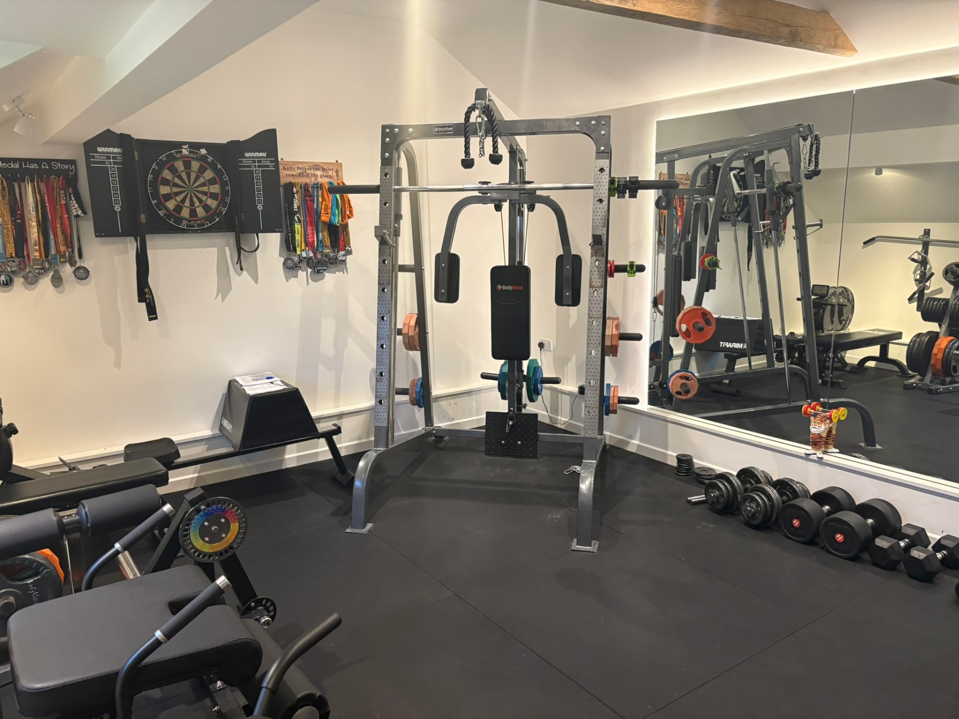 Home gym with cable machine, dumbbells and full-length mirror